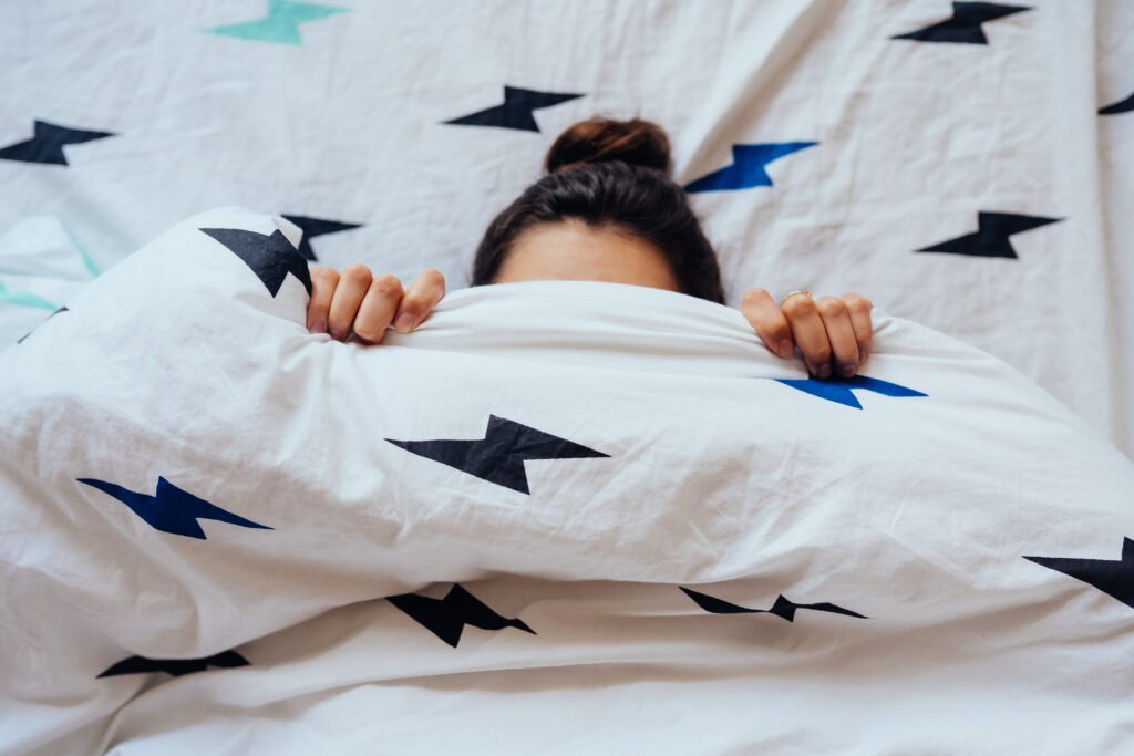 Estrés emocional Persona acostada en la cama cubriéndose con la cobija debido al estrés emocional, ansiedad e insomnio.